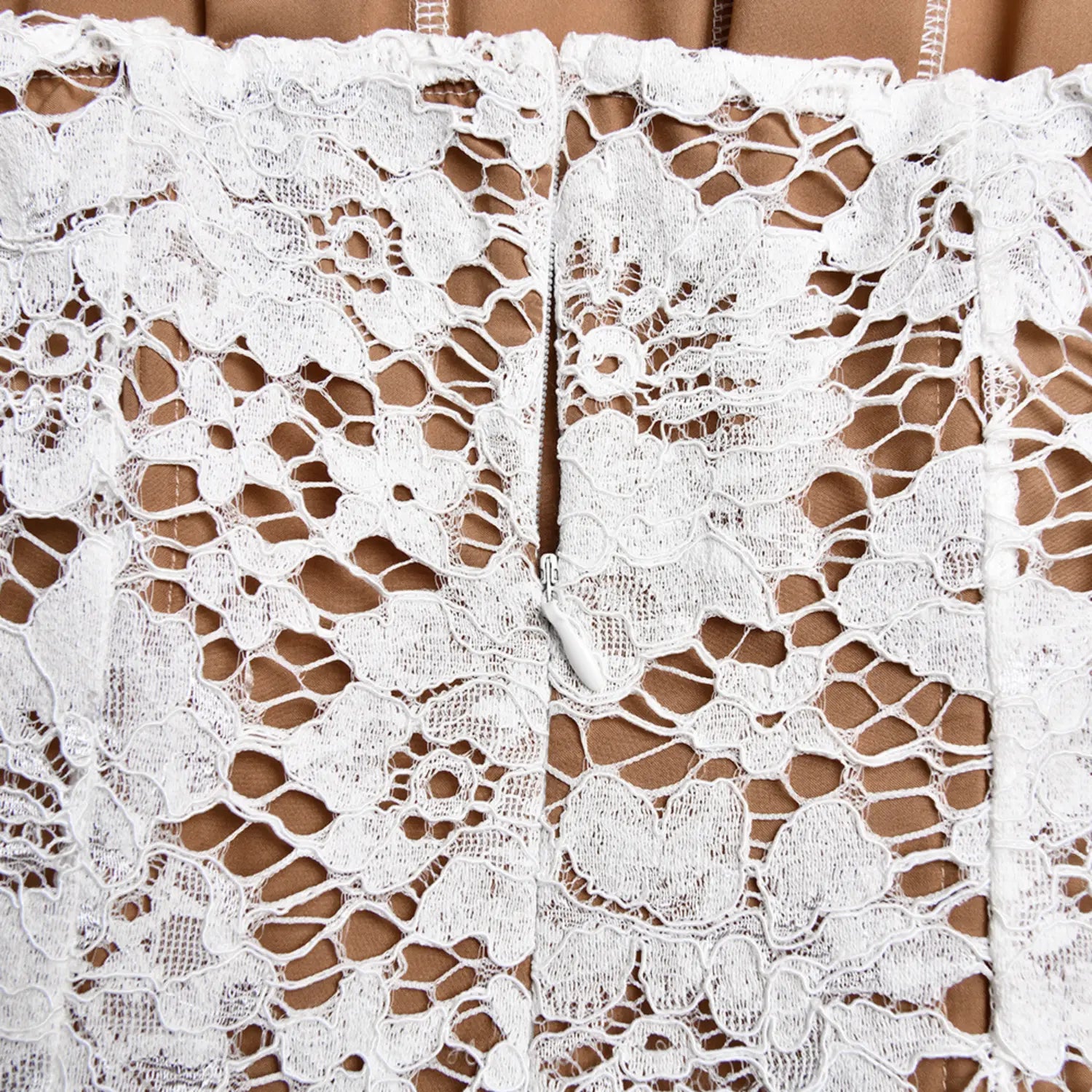 Close‑up back zipper fastener detail on white floral lace corset bodice