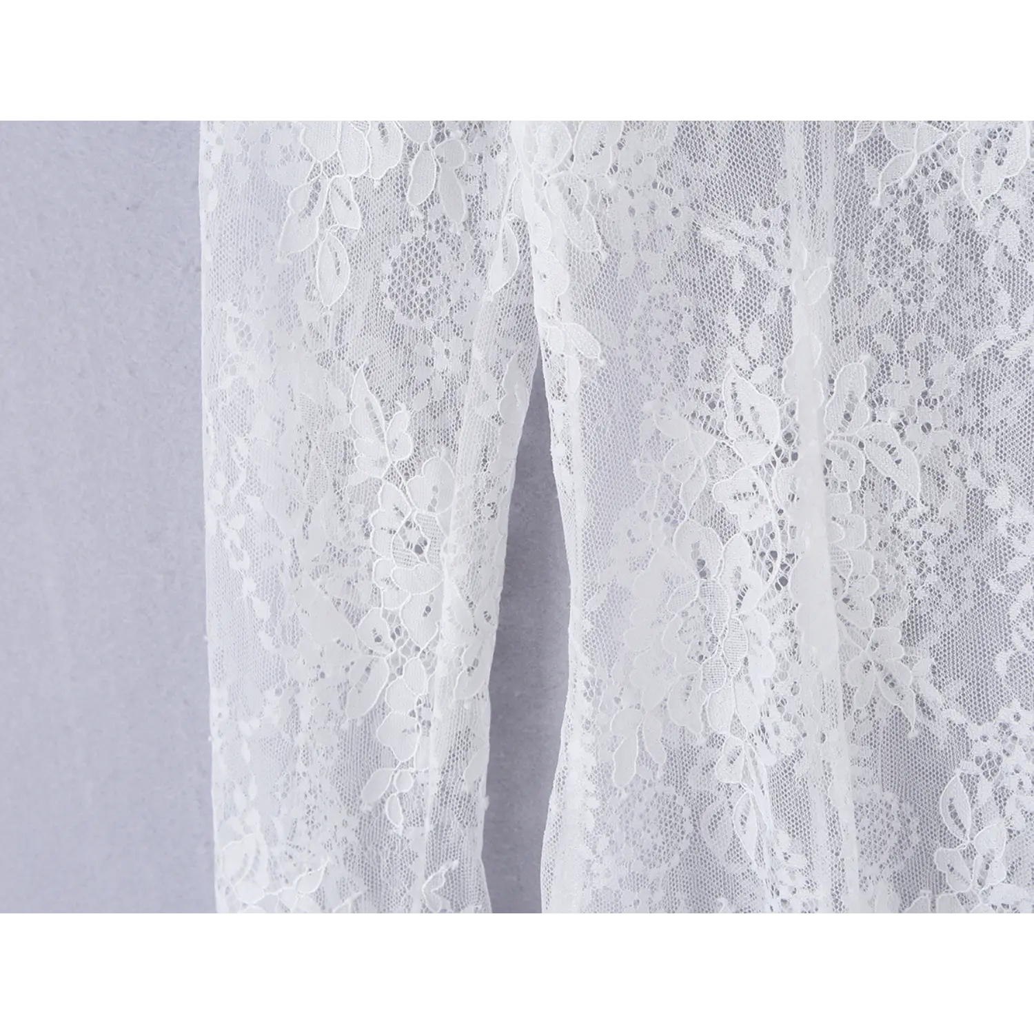 Close‑up showing fine stitching and sheer floral lace fabric on dress side panel