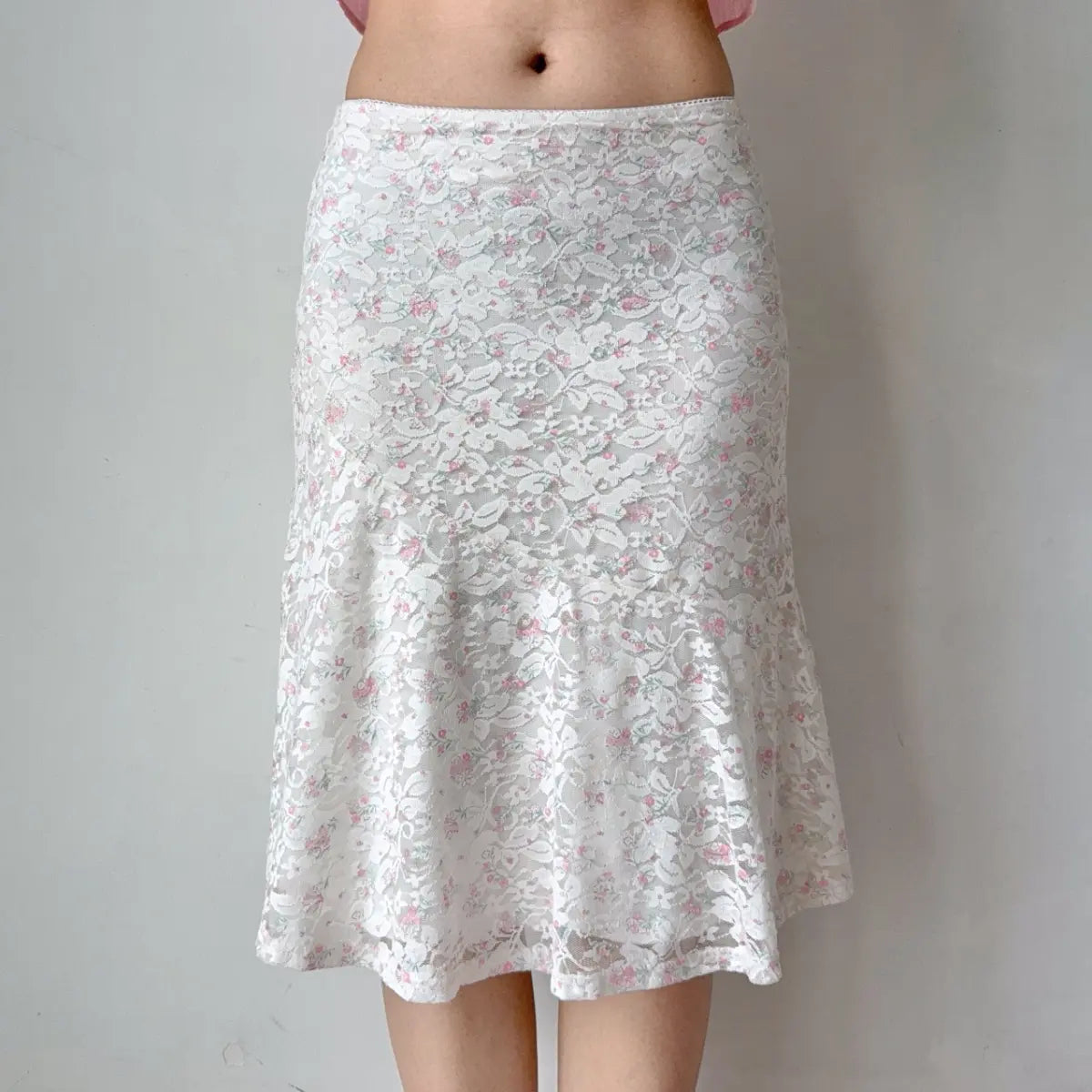 Close-up of the white floral lace midi skirt, showing the intricate lace pattern.