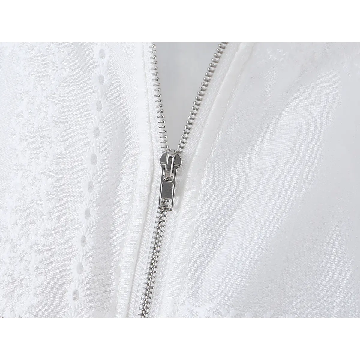 Close-up of the hidden center-back zipper on the embroidered fabric.