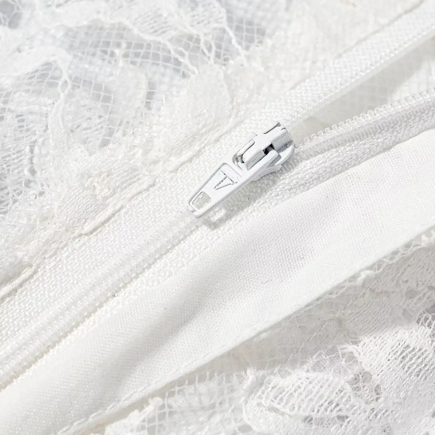 Macro close‑up white invisible zipper teeth and slider on white lace trousers