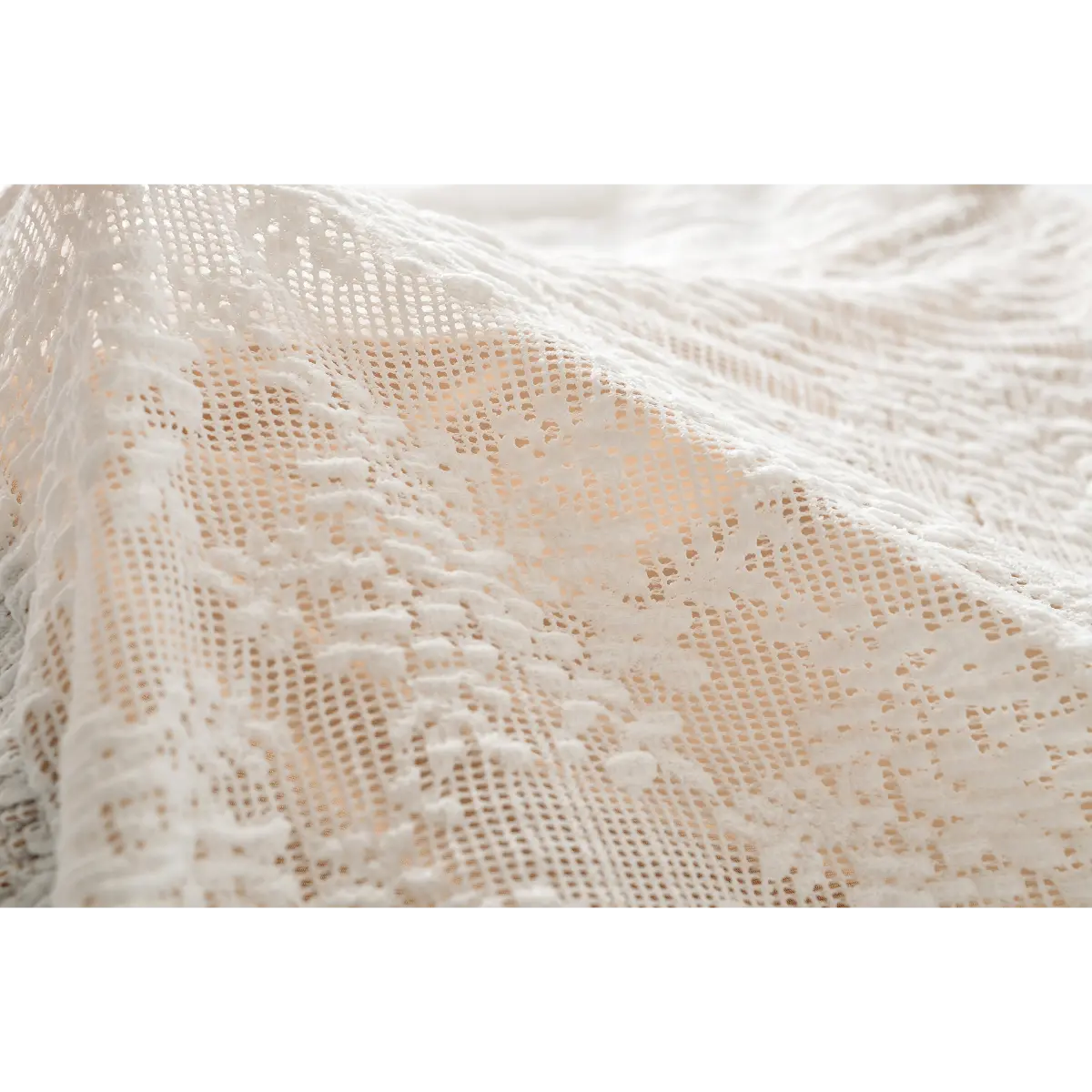 Close-up of the intricate lace texture and smocked fabric on the white V-neck top