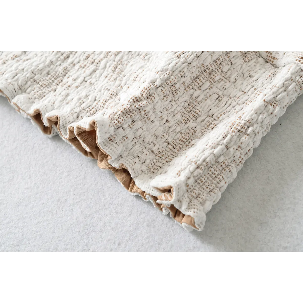 Close-up of the finished hem and lace texture on the white short-sleeve lace top