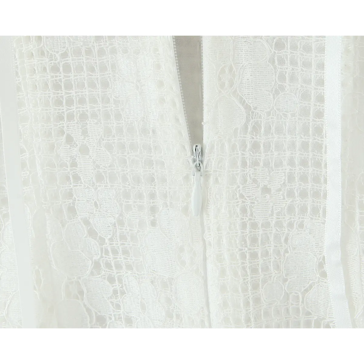 Close-up of the hidden back zipper closure on the white lace dress