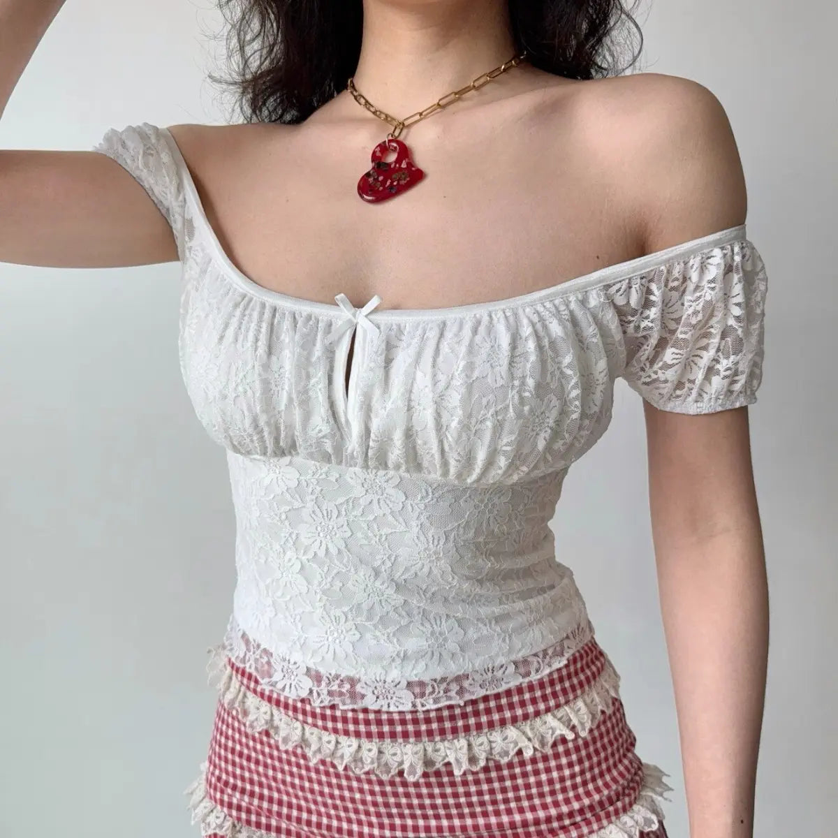 The lace top worn slightly off the shoulder, showcasing the puff sleeves and lace texture.