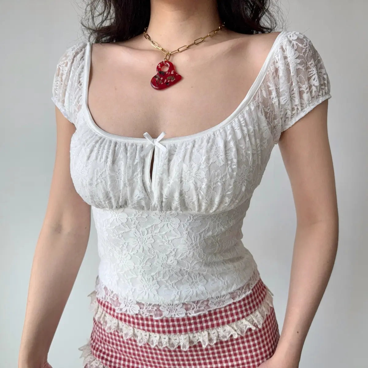 The lace top paired with a red and white gingham mini skirt, showing the complete outfit look.