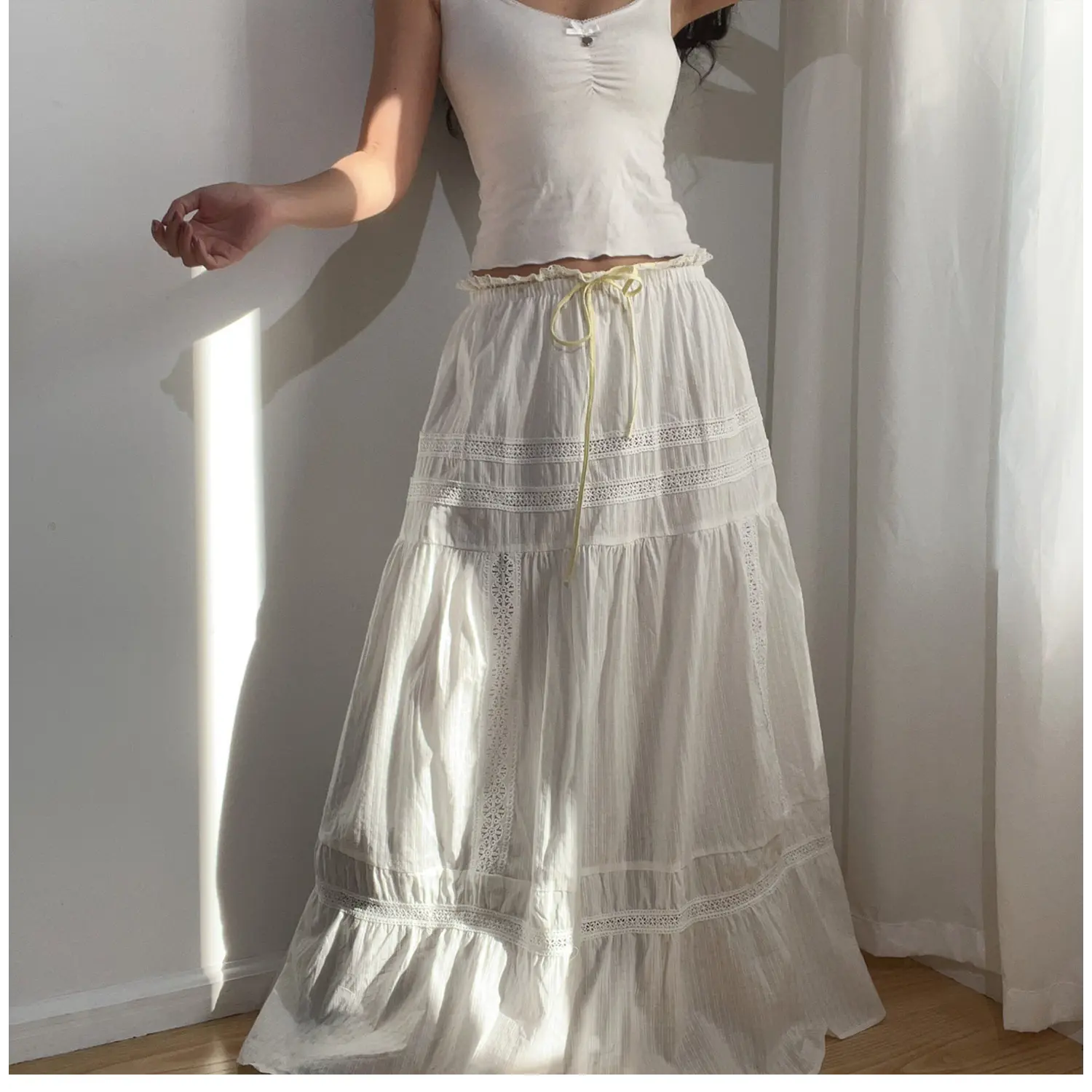  Lifestyle shot of the white lace tiered maxi skirt, showing the waist drawstring and lace tiers.