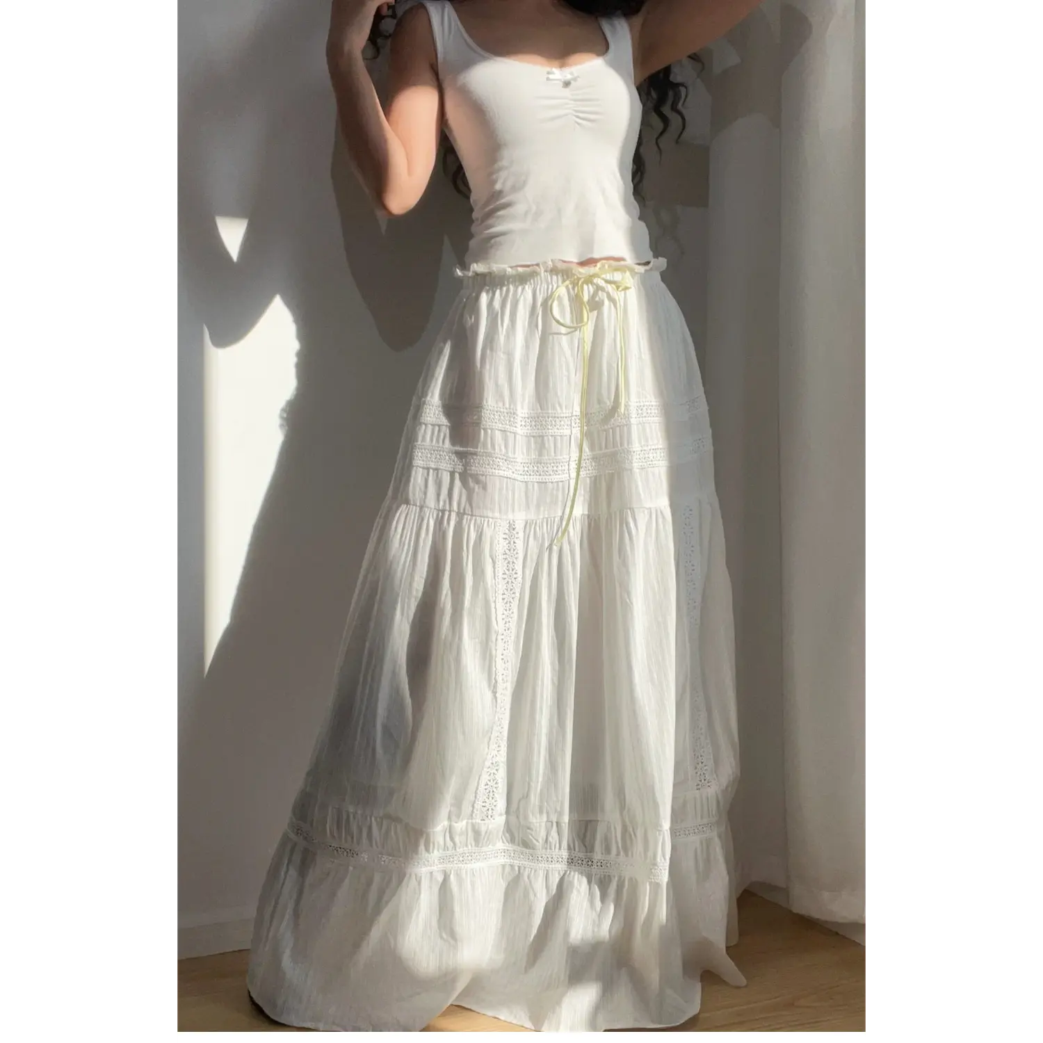 Seated lifestyle shot of the white lace tiered maxi skirt, showing how the lace tiers drape.