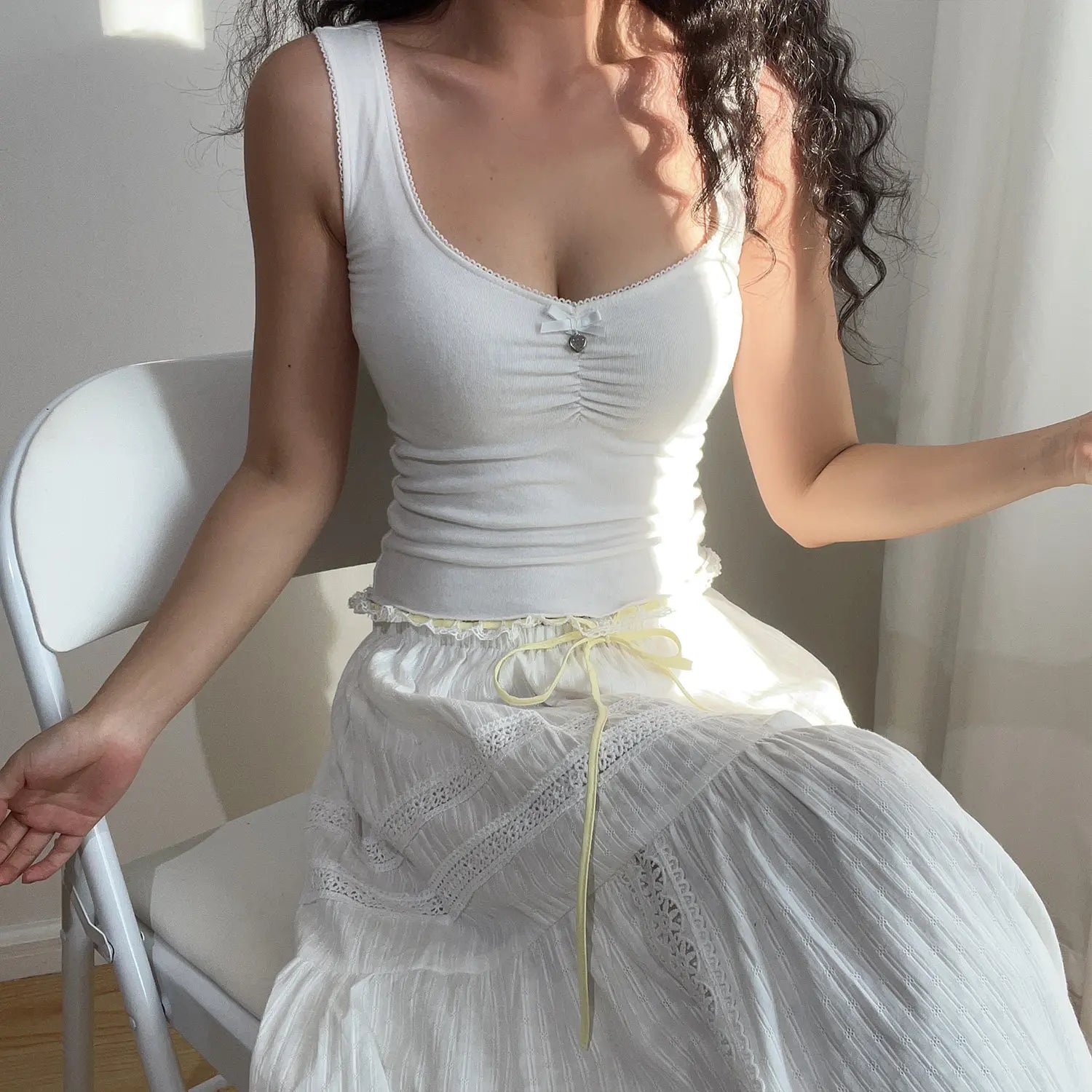 Close-up of the skirt tiers, showing the textured fabric and eyelet lace details on the white maxi skirt.