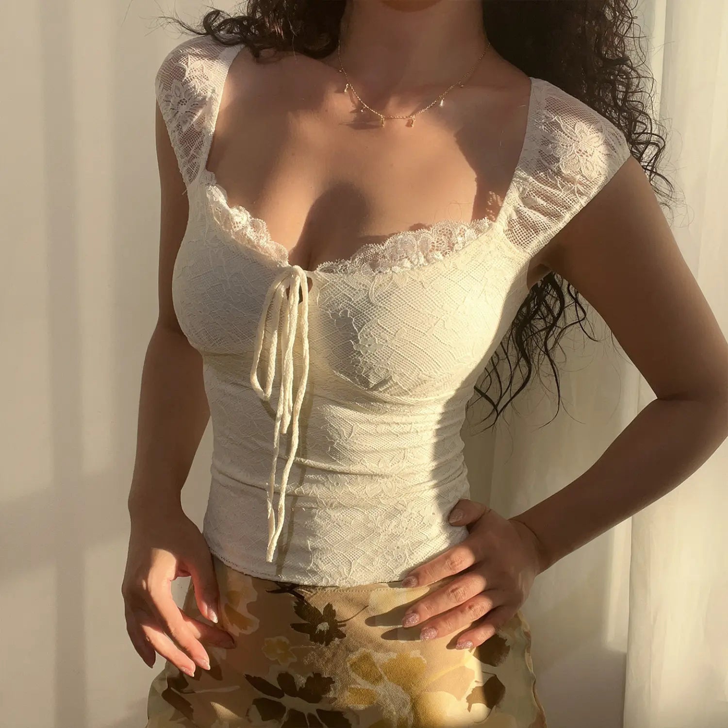 White lace top model hand on waist side shot, side waist ruched design slim silhouette full cap lace sleeves cropped length lengthen leg proportion soft daily vibe outfit shot