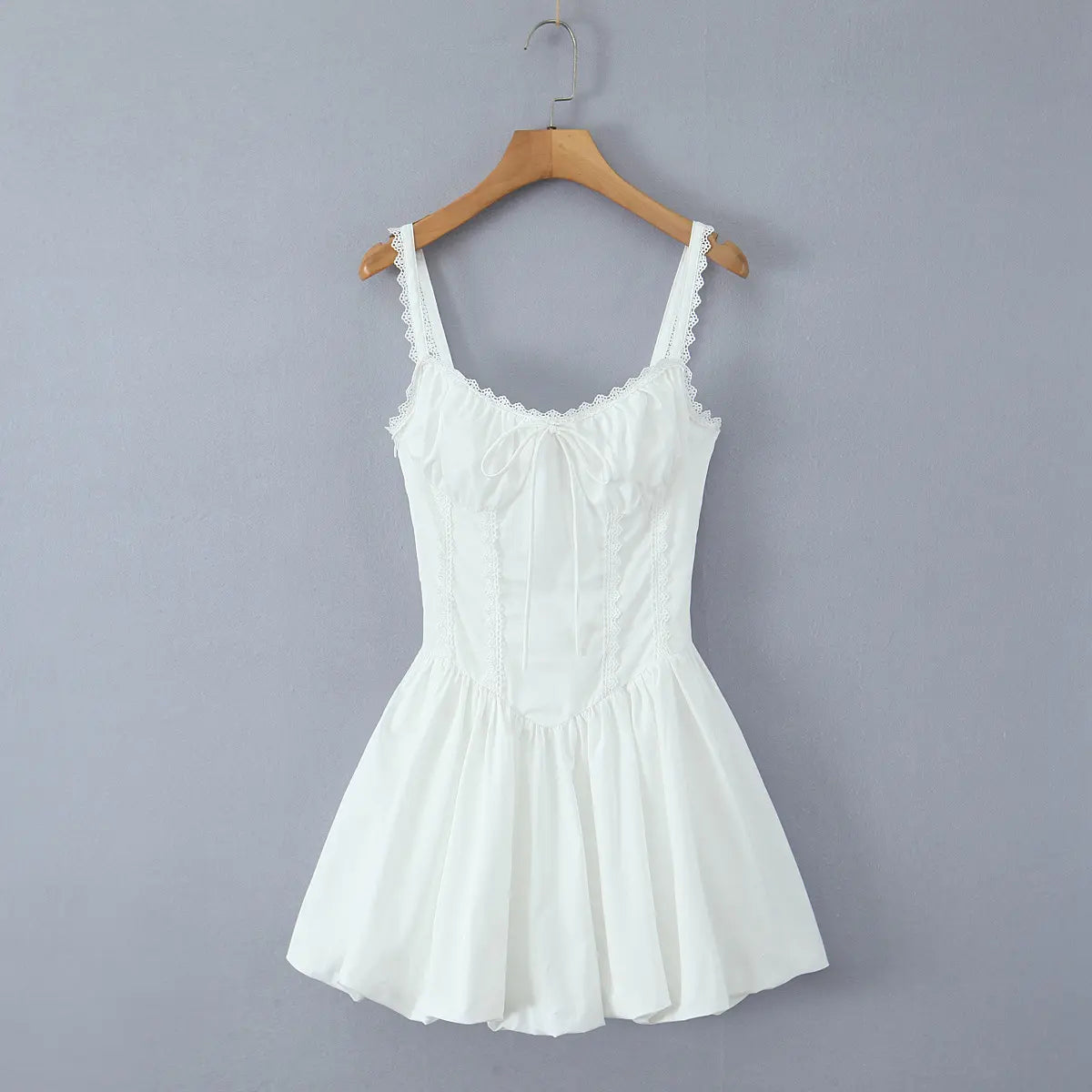 Full front view on wooden hanger of the white lace-trim corset-style puffball mini dress