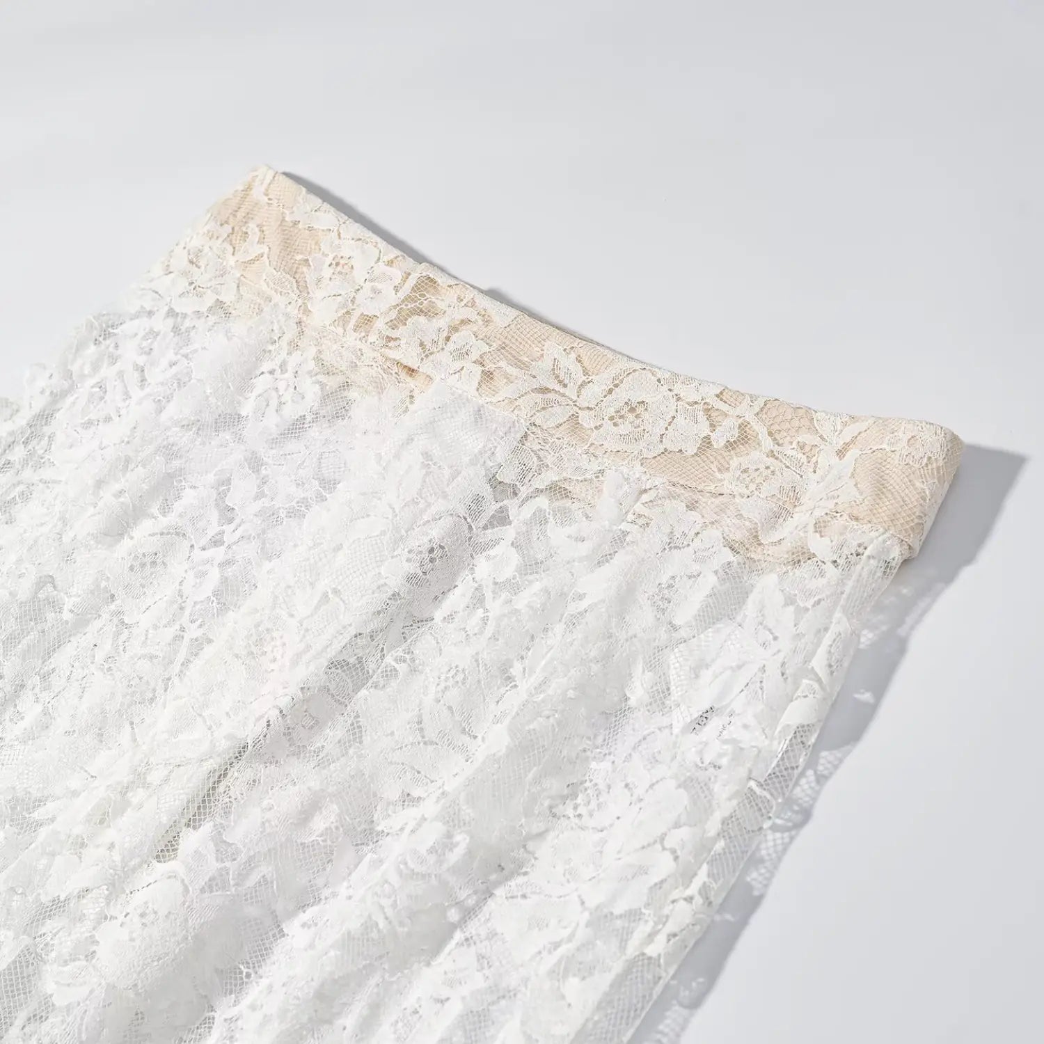Close‑up overview beige inner waistband with overlay white floral lace for wide leg trousers