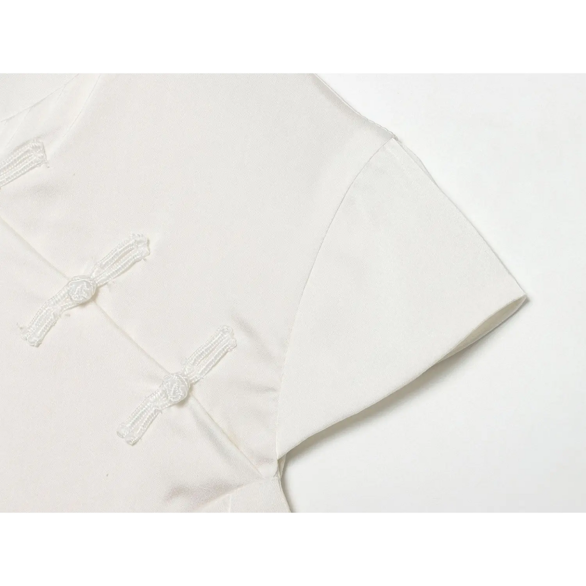 Close-up of frog buttons and short sleeve