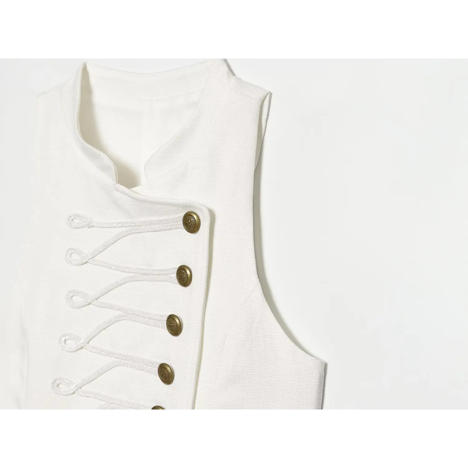 Macro shot of decorative braided cord embroidery and embossed vintage gold buttons on white dress