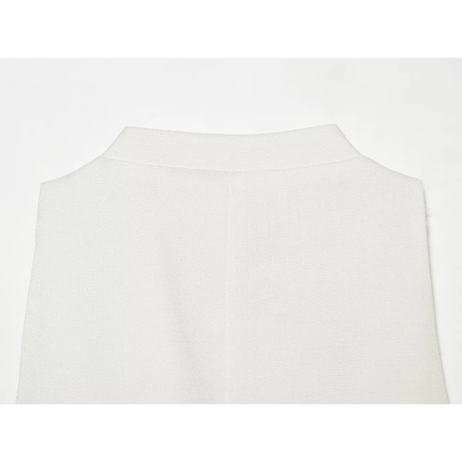 Close‑up back view of stand collar and back woven fabric texture on white sleeveless mini dress