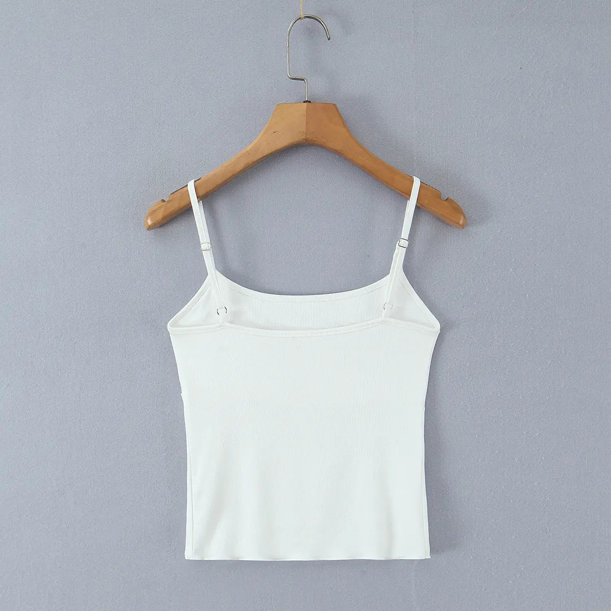 Full back view of the white cami top, showing adjustable spaghetti straps and a simple ribbed knit back.