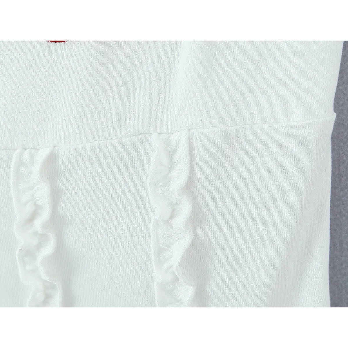 Close-up of the vertical ruffled trim at the front waistline, showing the gathered, frilly fabric.