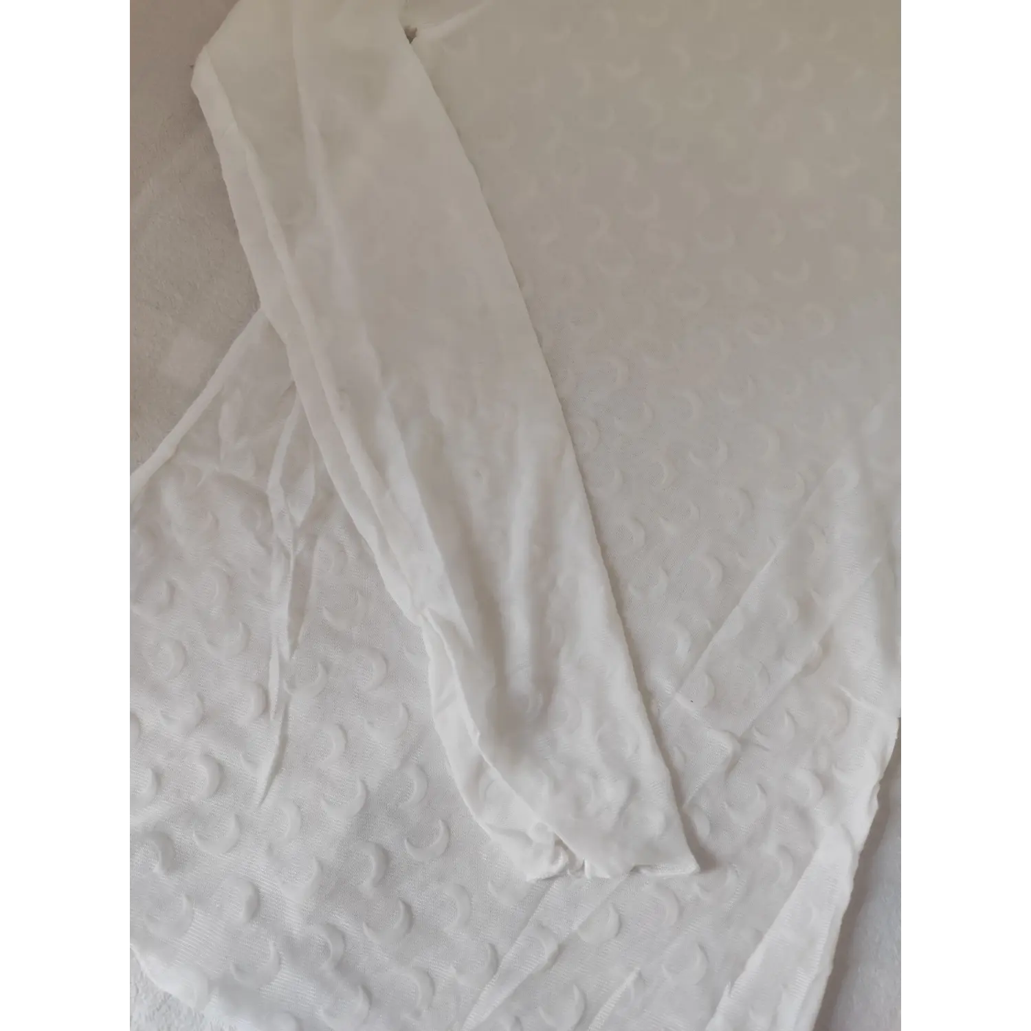 Long sleeve detail of white sheer crescent moon turtleneck blouse