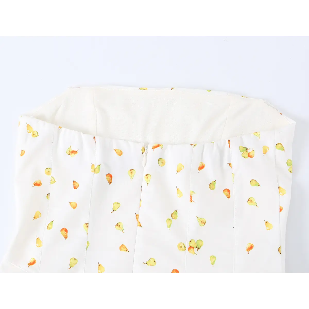 Close-up back view of a white strapless mini dress with watercolor pear print, showing the center zipper and elasticated top edge.