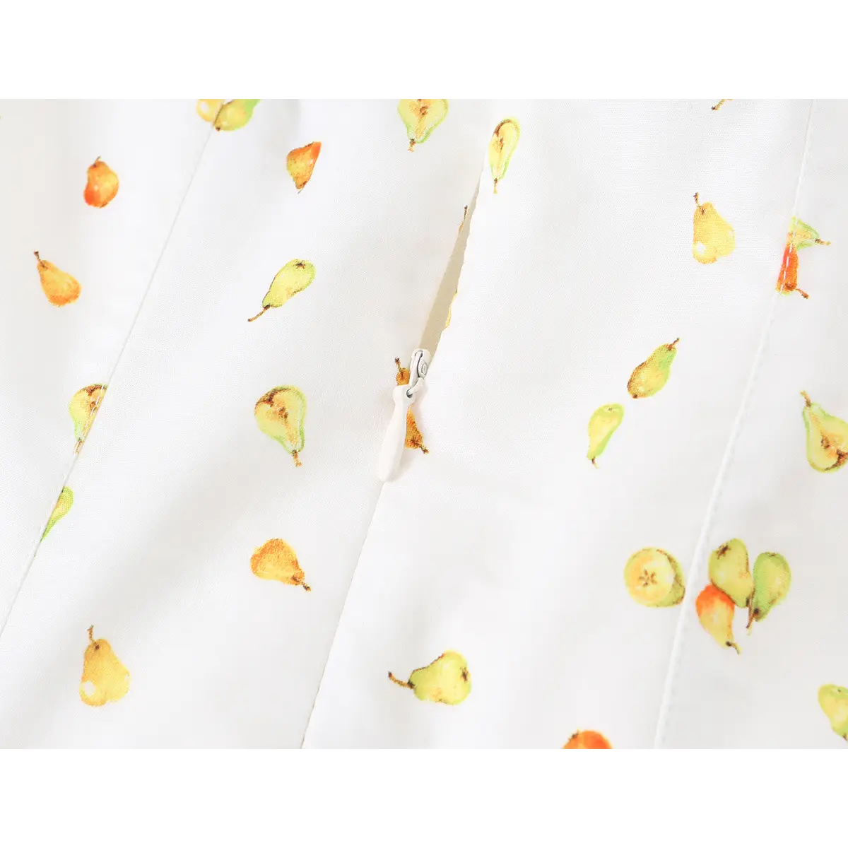 Close-up detail of the white center zipper on a strapless mini dress with watercolor pear print.