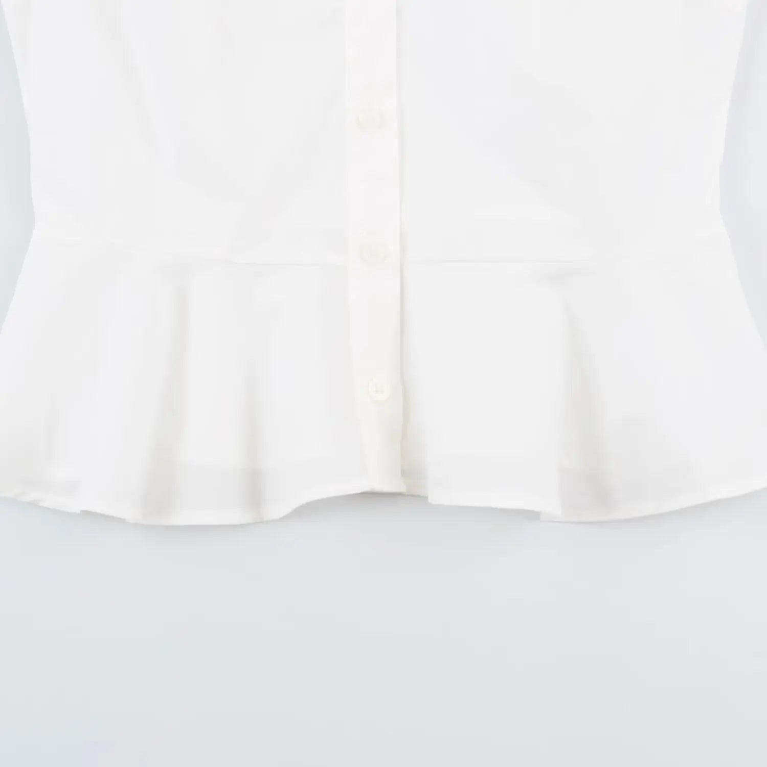 Lower shot peplum ruffle hem and front buttons of white fitted short blouse