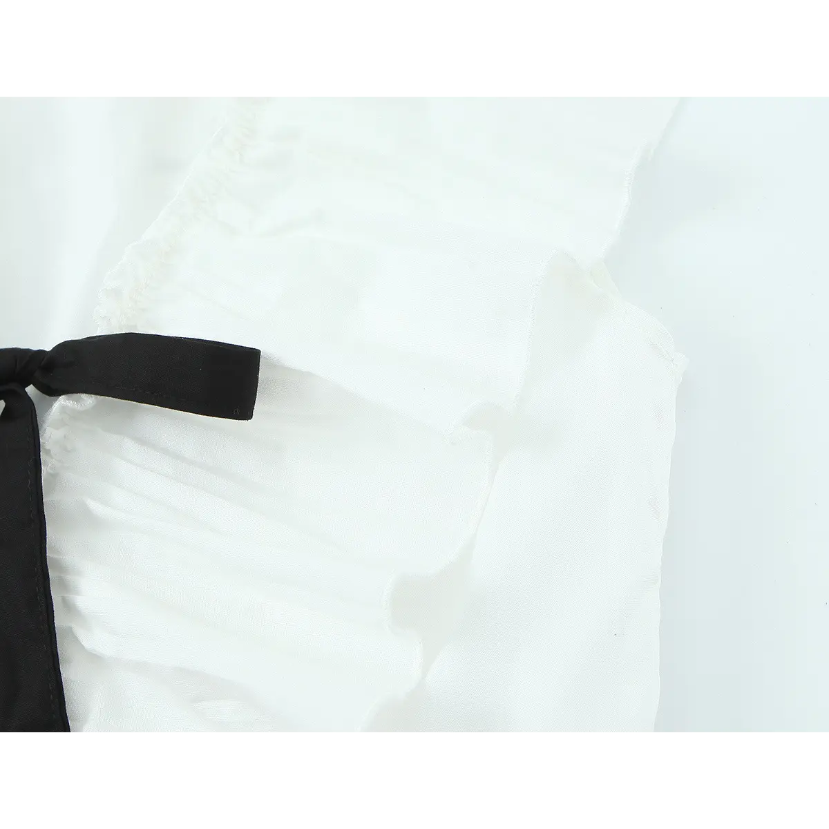 Close-up of the side detail, showing the black ribbon tie, pleated ruffle sleeve, and layered fabric