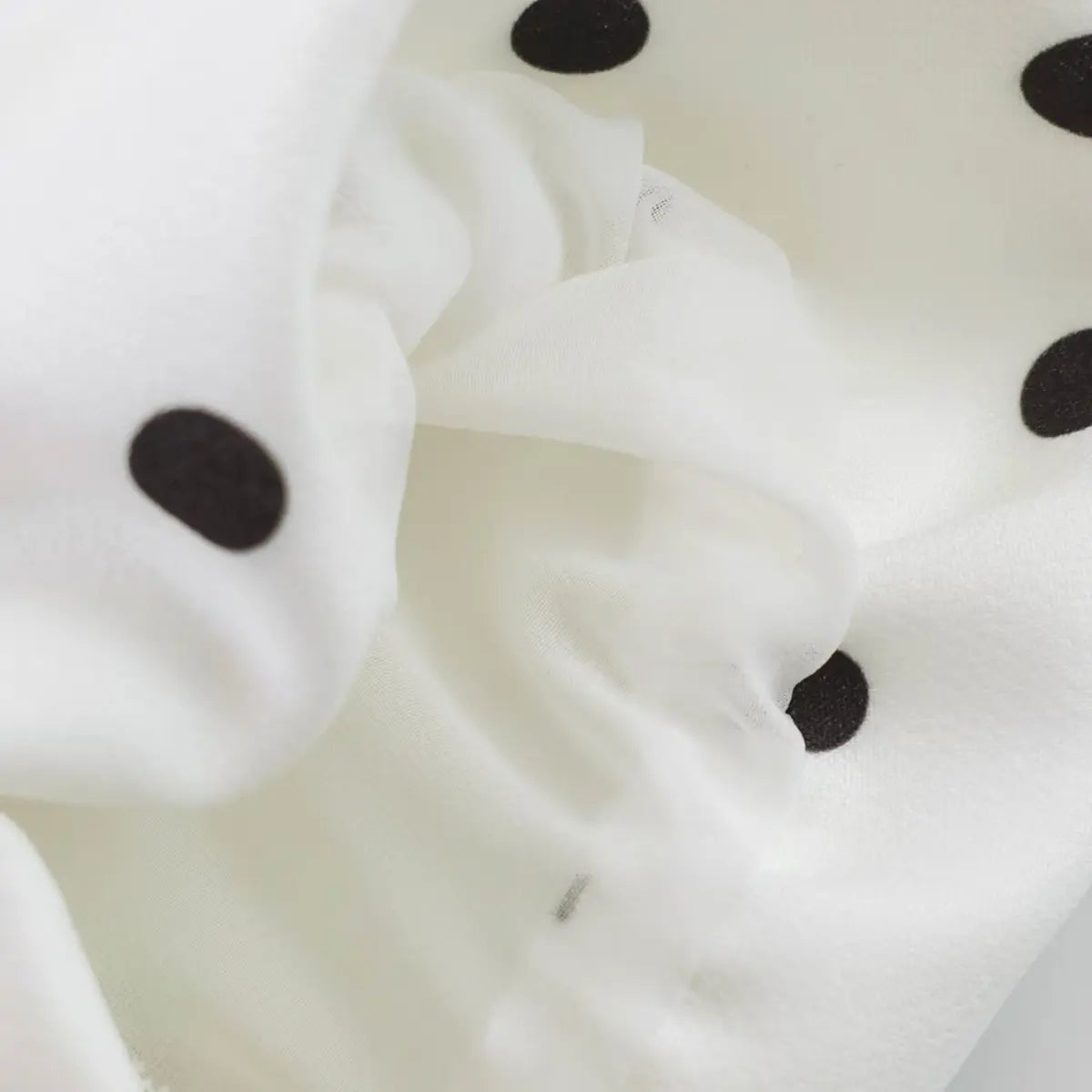 Close-up of the lightweight fabric texture, showing the semi-sheer quality and dot print clarity.