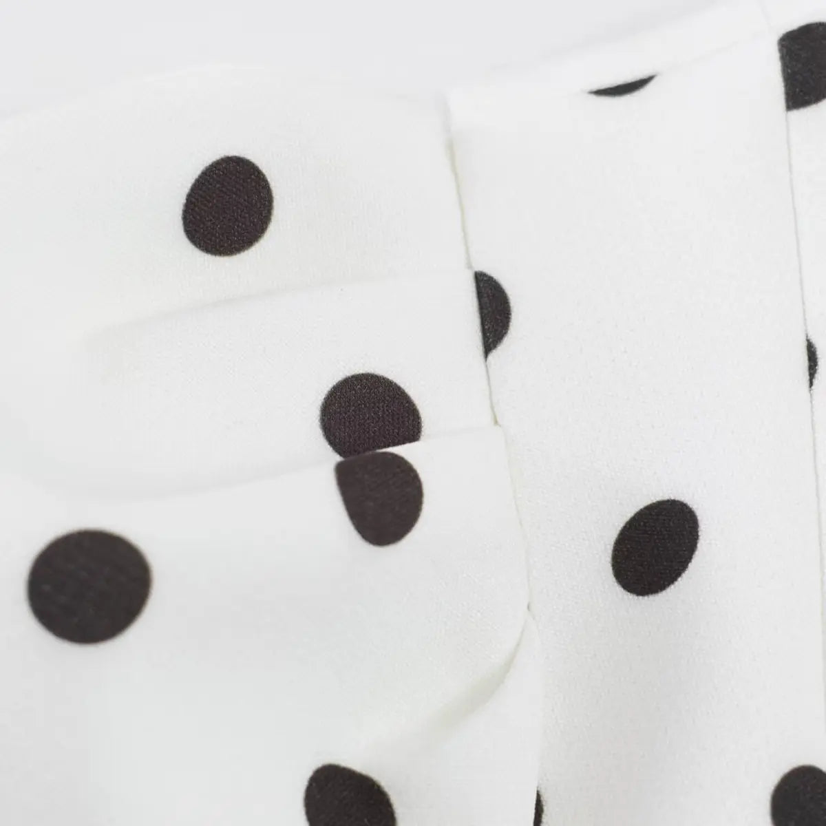 Close-up of the gathered tuck detail on the puffed sleeve, showing the fabric texture and dot print.