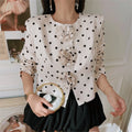 Model front wearing white polka dot cropped jacket with 3D rose flowers, matching black skirt fashion outfit