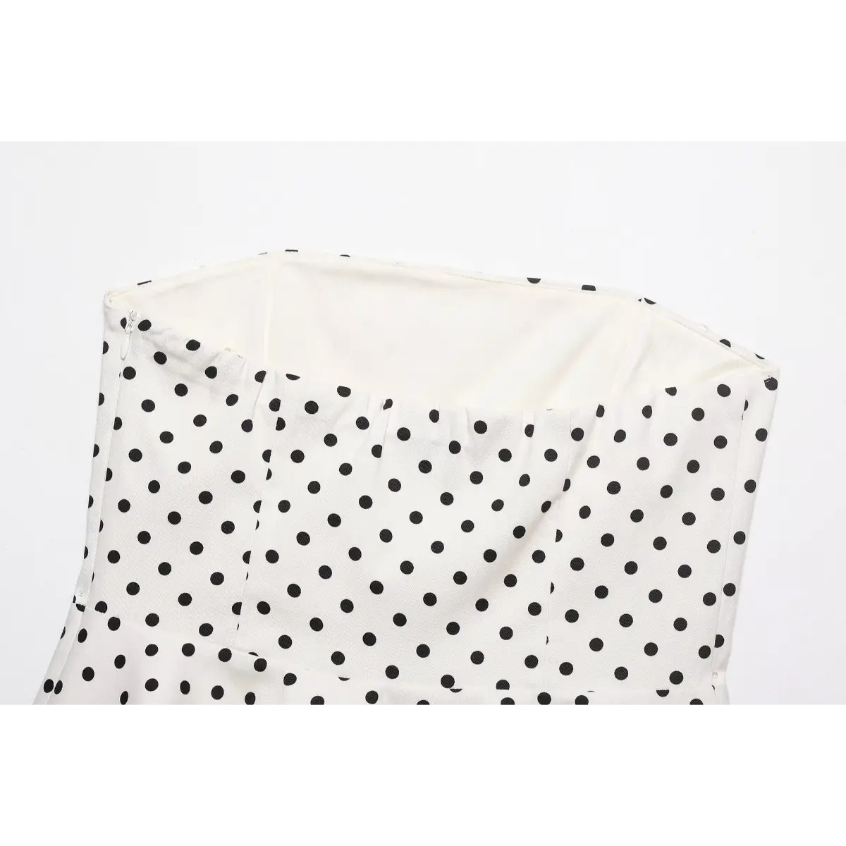 Close-up of the top silhouette and inner lining on the white polka dot strapless top