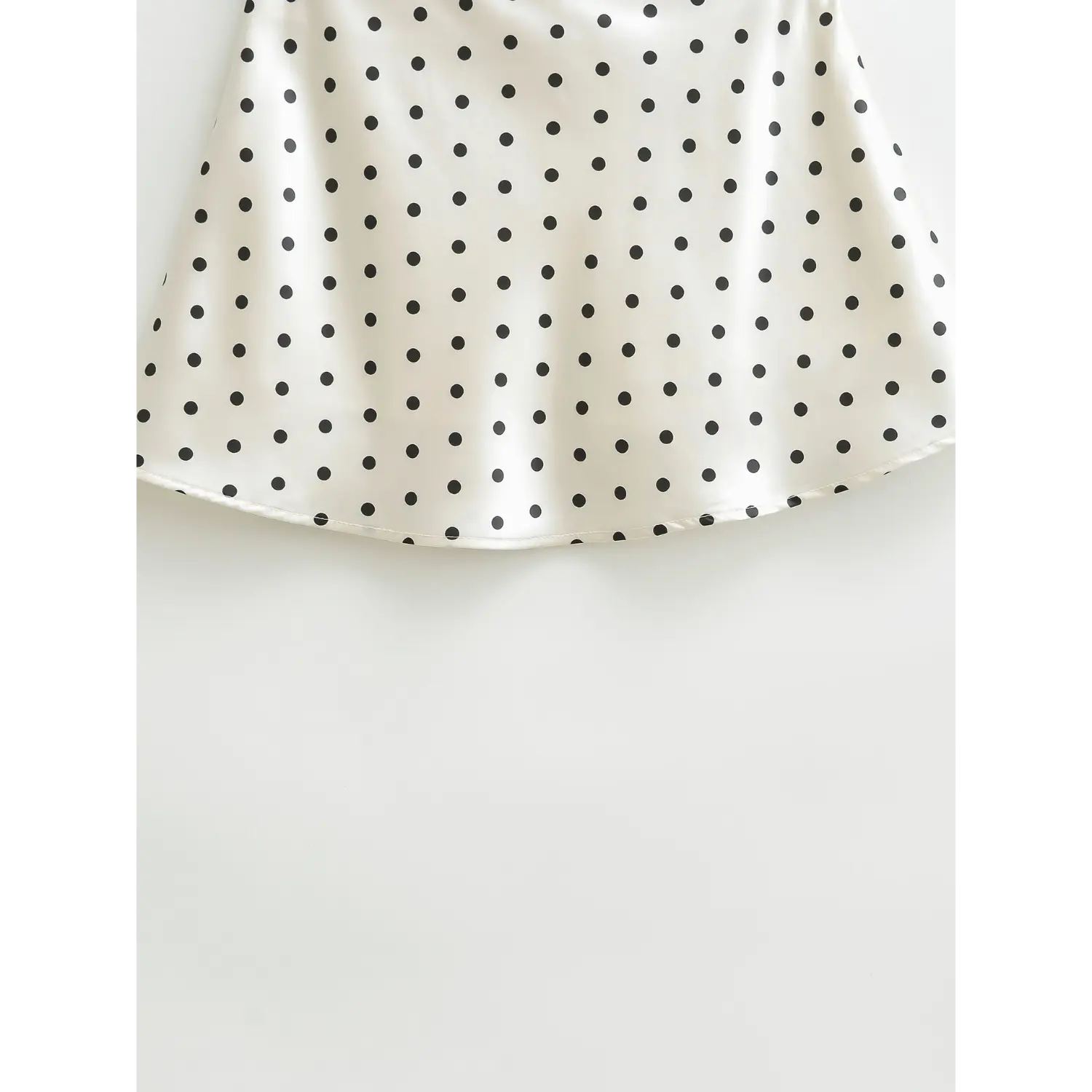 Full bottom drape shot of polka dot silky satin mini skirt, lightweight flared hem on plain white background