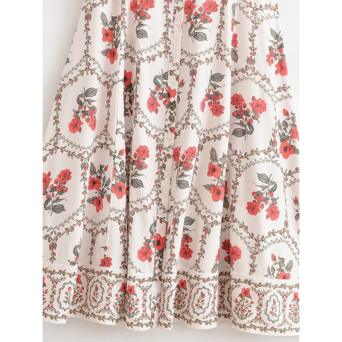 Close-up of flowing maxi dress skirt with red floral print, soft gathers and relaxed tiered silhouette