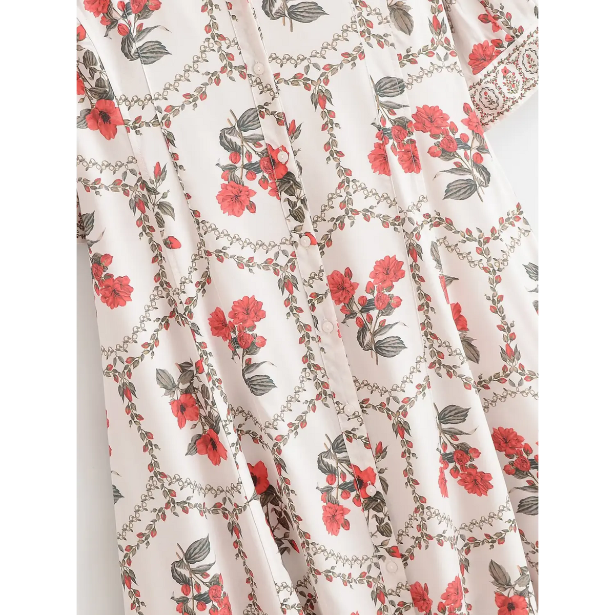 Detail shot of button front on white botanical maxi dress, showing vertical buttons and repeating red flower pattern