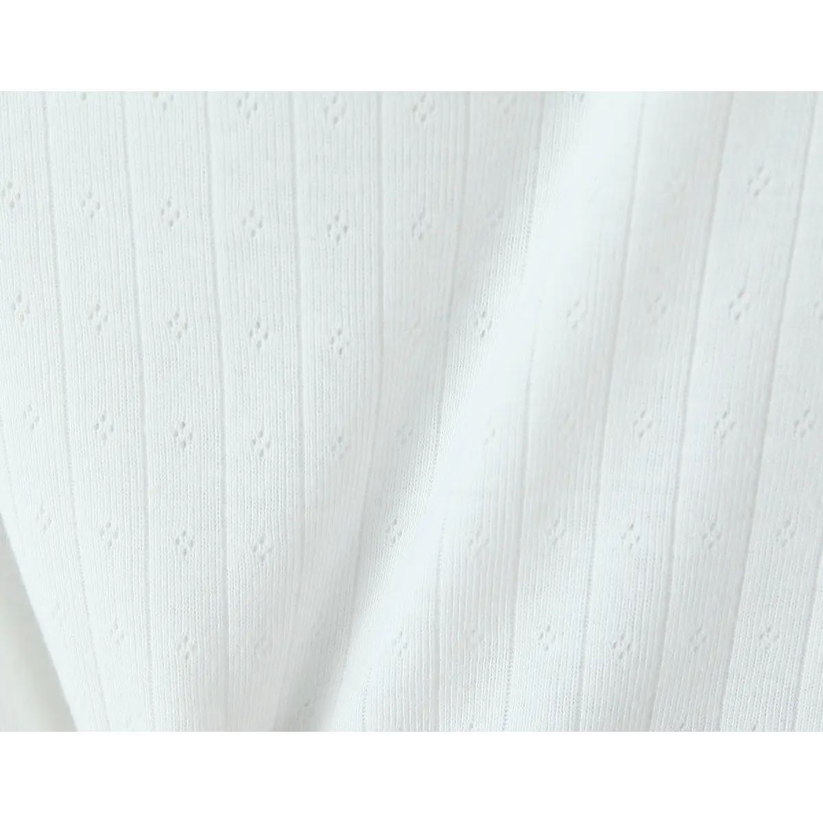 Close-up of the knit fabric, showcasing the vertical ribbing and delicate eyelet knit pattern.