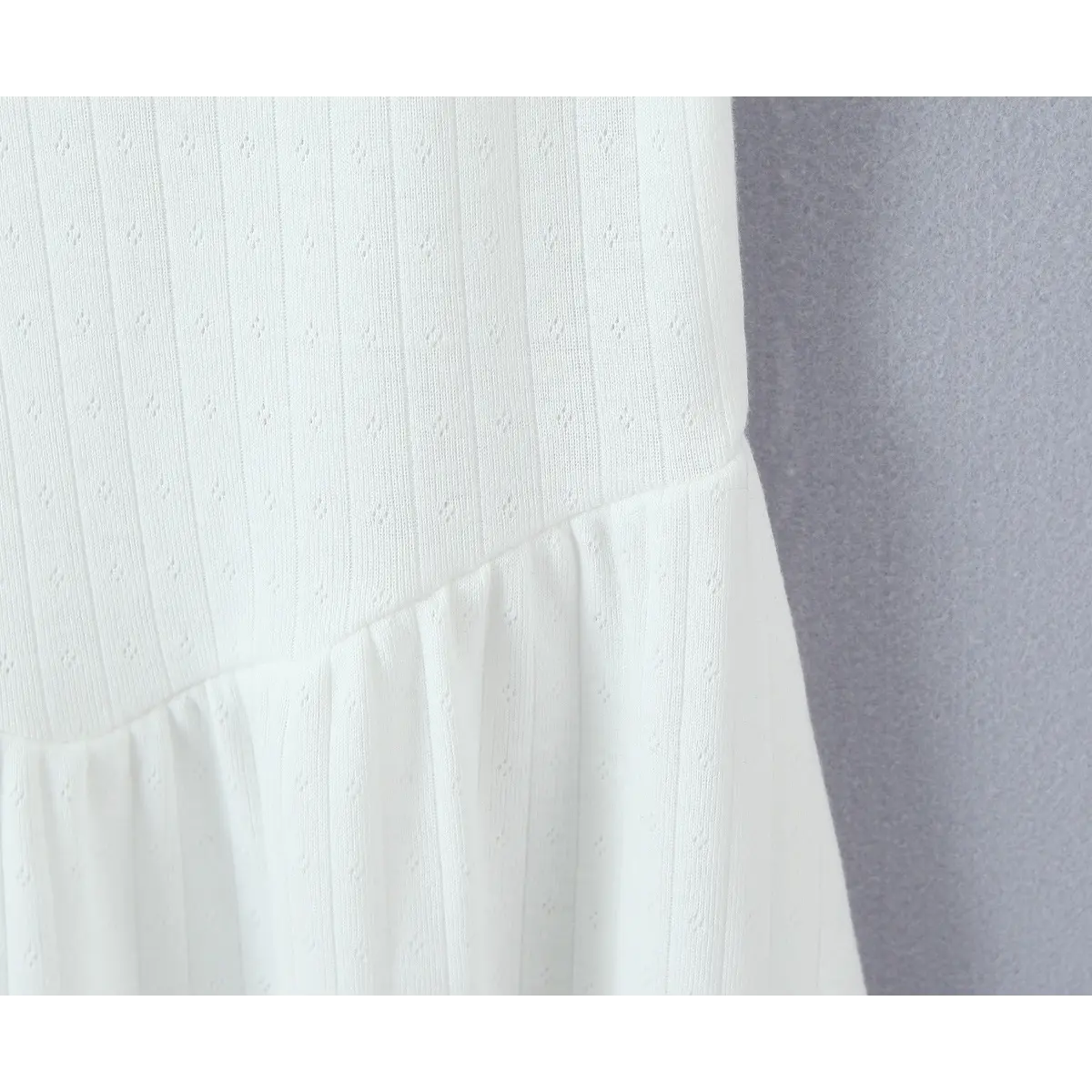 Close-up of the waist seam where the fitted bodice transitions into the gathered, flared skirt.