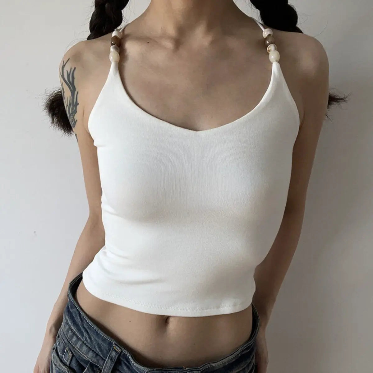 Lifestyle shot of white ribbed camisole with beaded straps and crisscross back