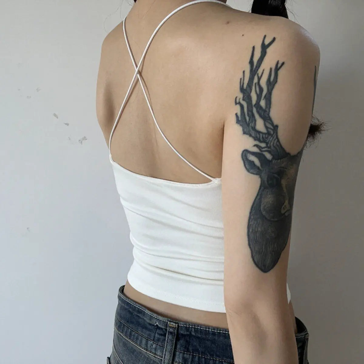 Back view detail shot of white ribbed camisole, showing the crisscross straps