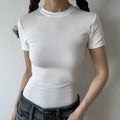 Lifestyle shot of form-fitting white ribbed crew-neck t-shirt, tucked into jeans