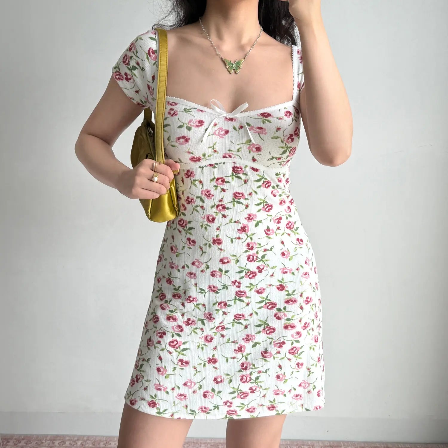 Front lifestyle shot on model of floral ribbed casual mini dress, square neckline, front bow, fitted silhouette