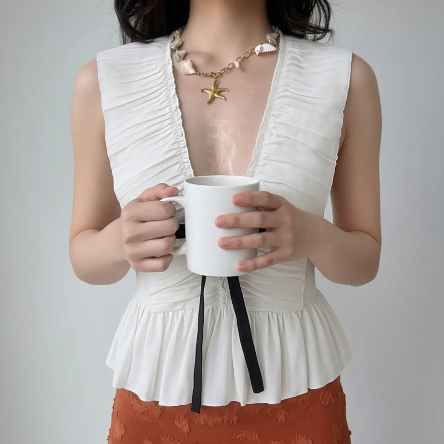 Front lifestyle shot on model, deep V sleeveless ruched peplum top with front black ribbon drawstring, lightweight chiffon fabric, sweet casual outfit