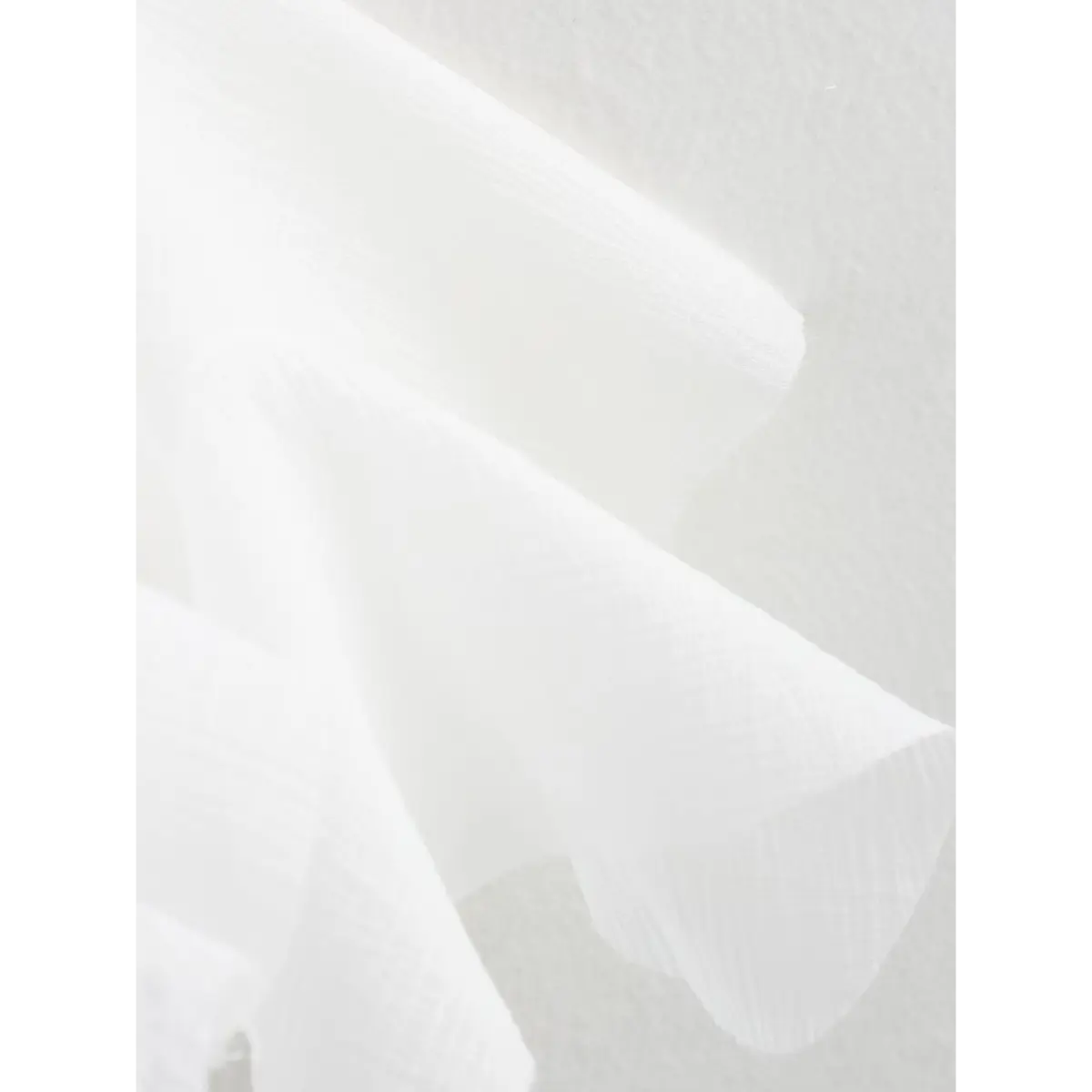 Close-up of the dress's textured white fabric and ruffled hem.