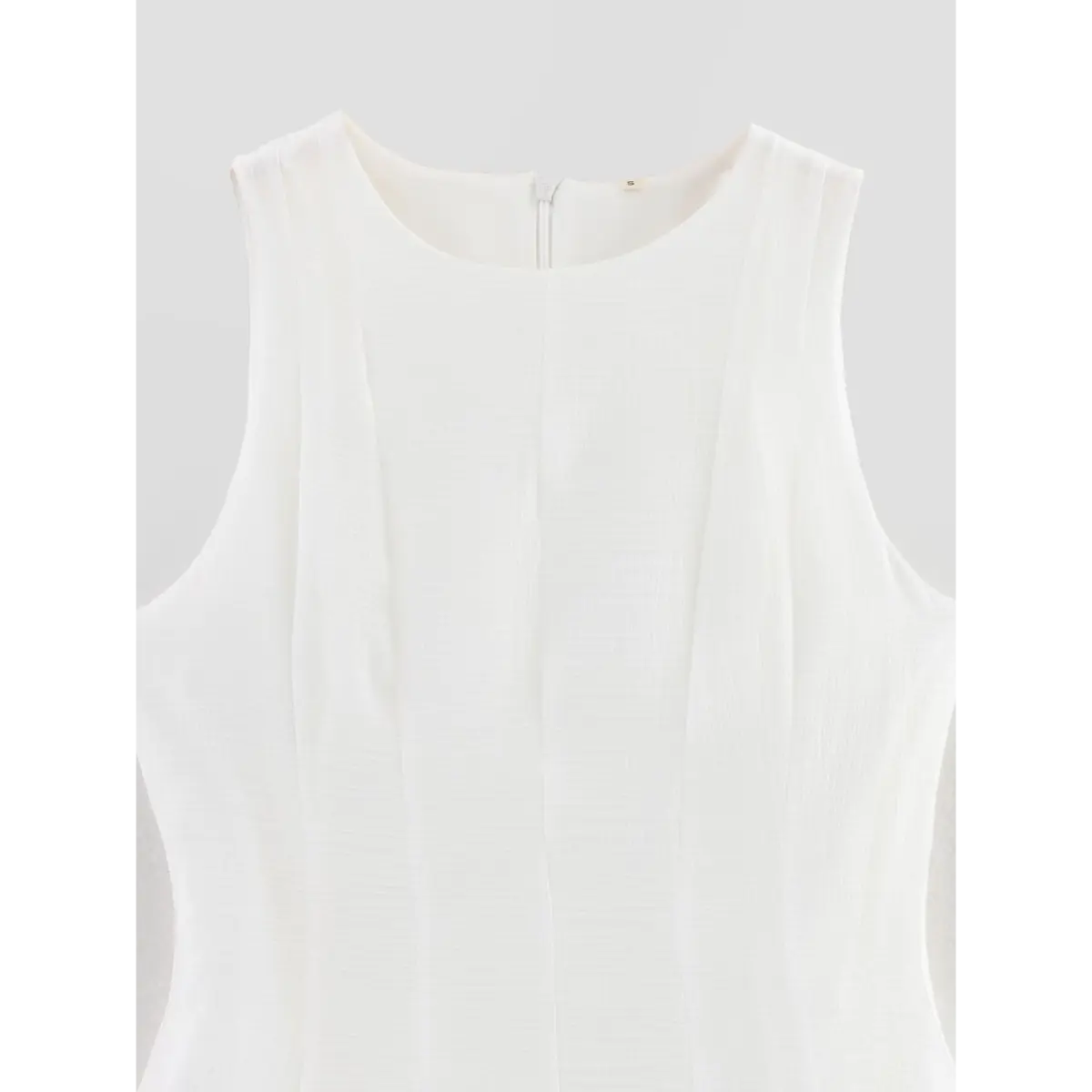  Close-up of the dress's front neckline, showing the panel construction and label.