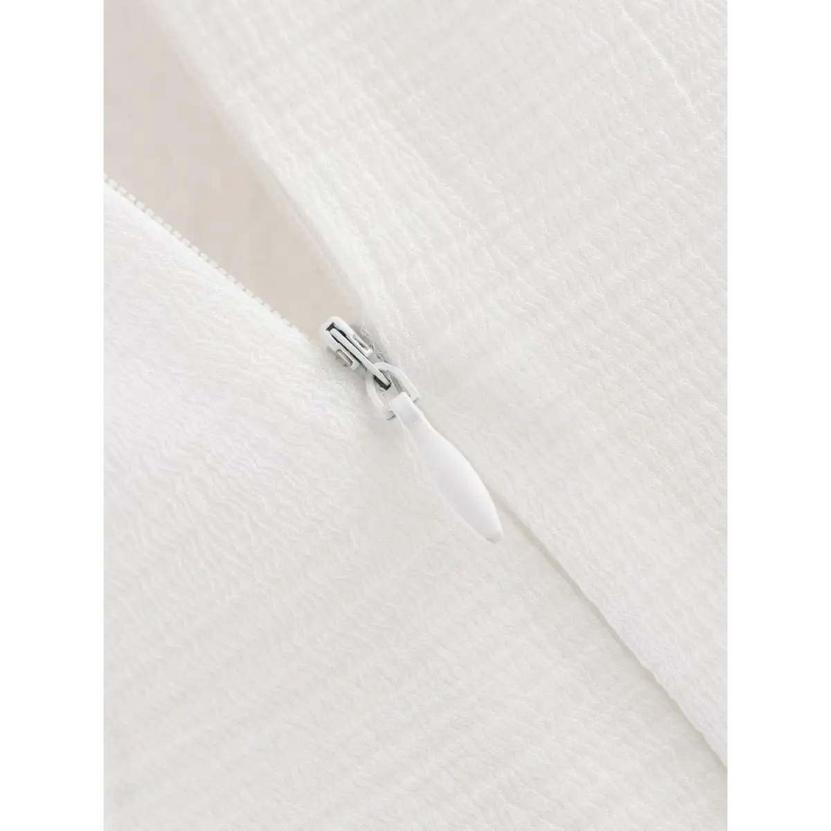 Close-up of the dress's white zipper pull.