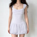 Model wearing pure white satin corset mini dress with folded draped bust structured corset torso and voluminous bubble hem skirt