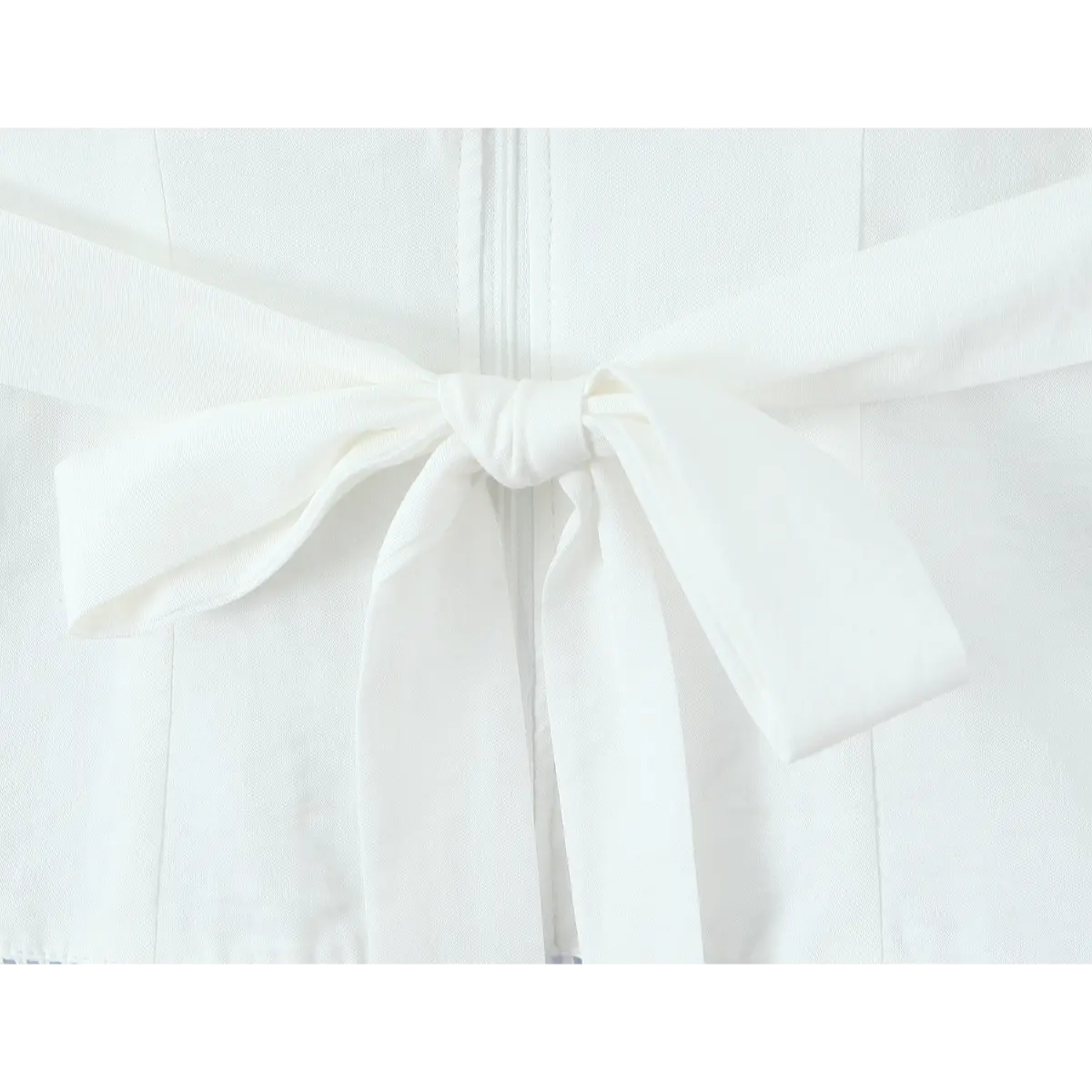 Close-up of the fabric waist tie, tied in a bow at the back of the camisole.