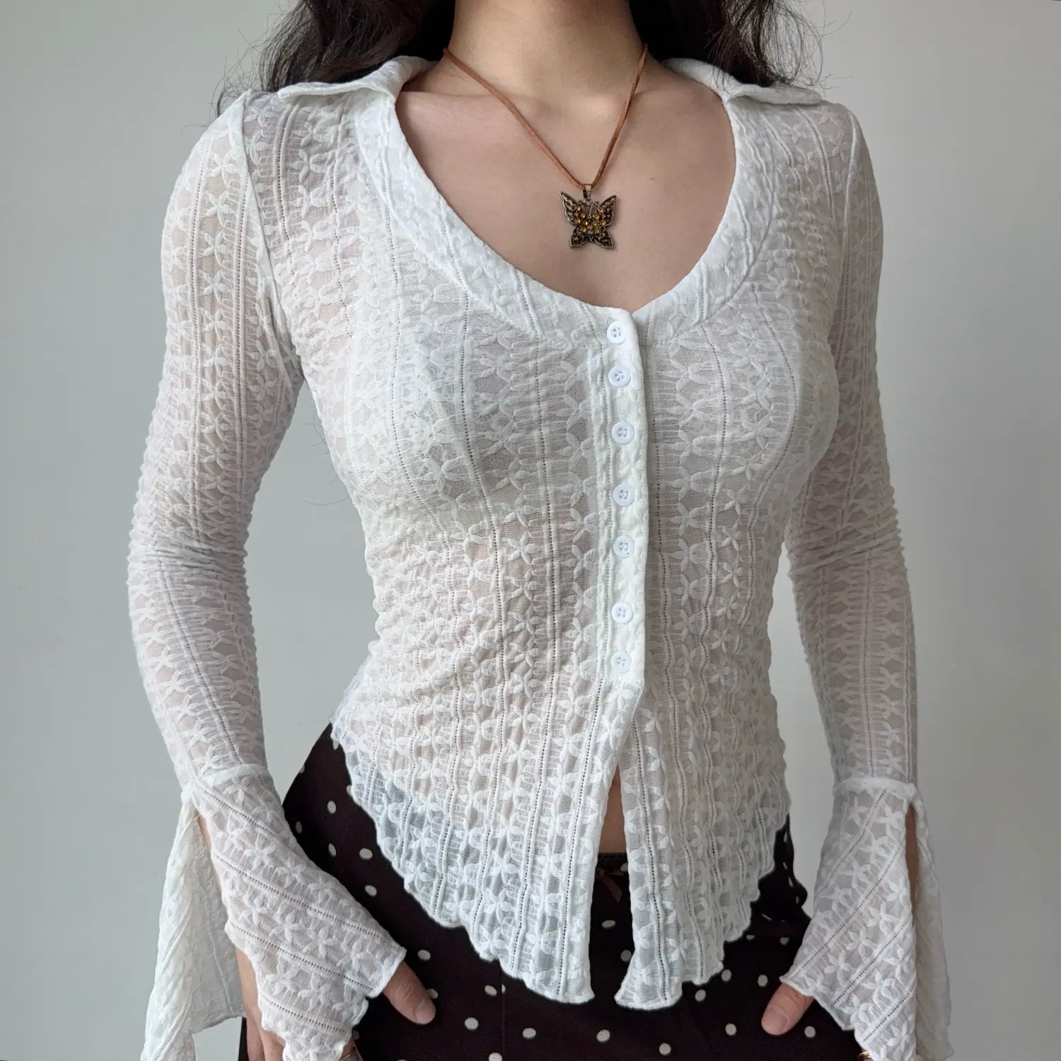 Front close‑up shot white sheer lace collared long sleeve top highlighting button placket and flared split cuff details