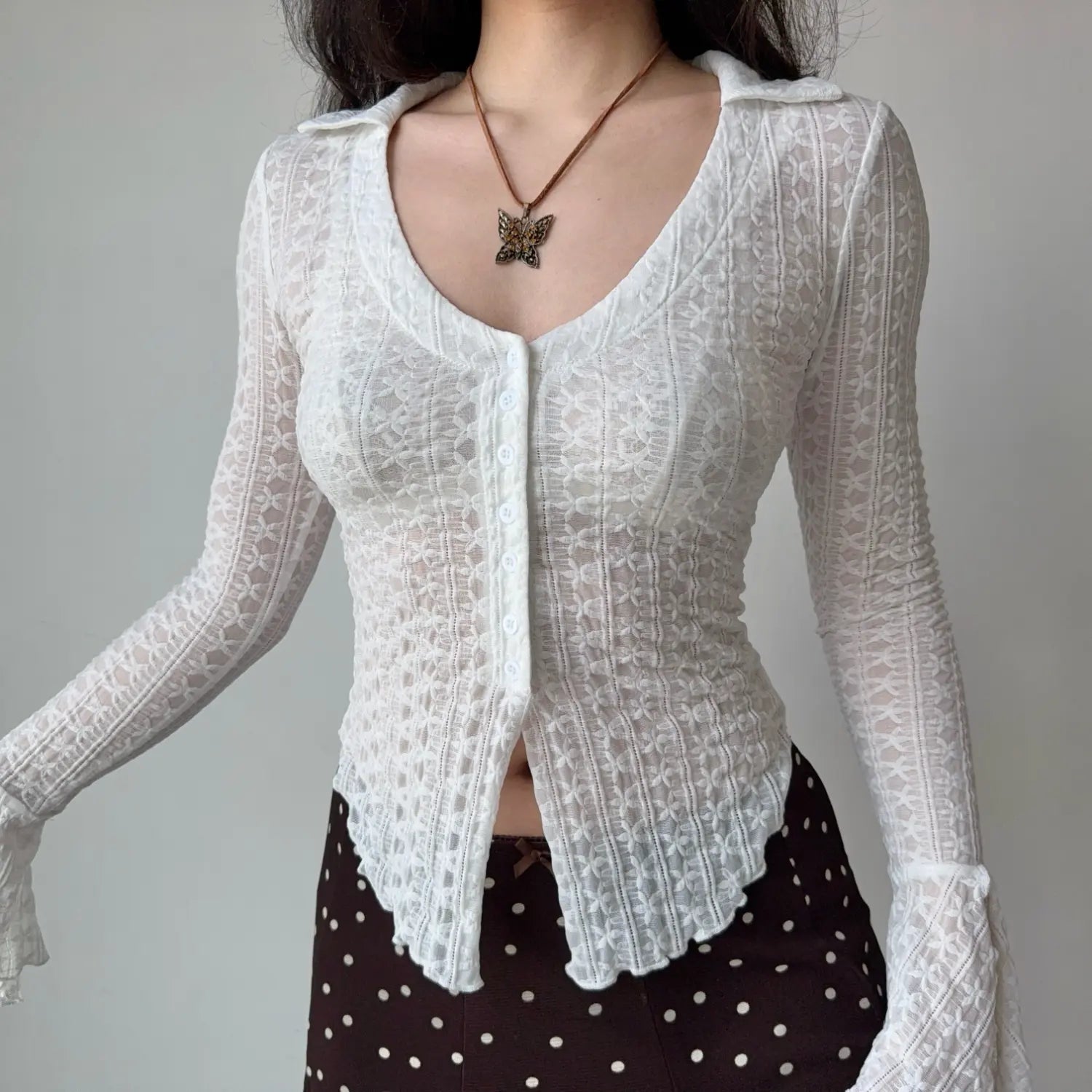 Model relaxed front shot white sheer lace collared v‑neck button‑front long sleeve top scalloped uneven hem