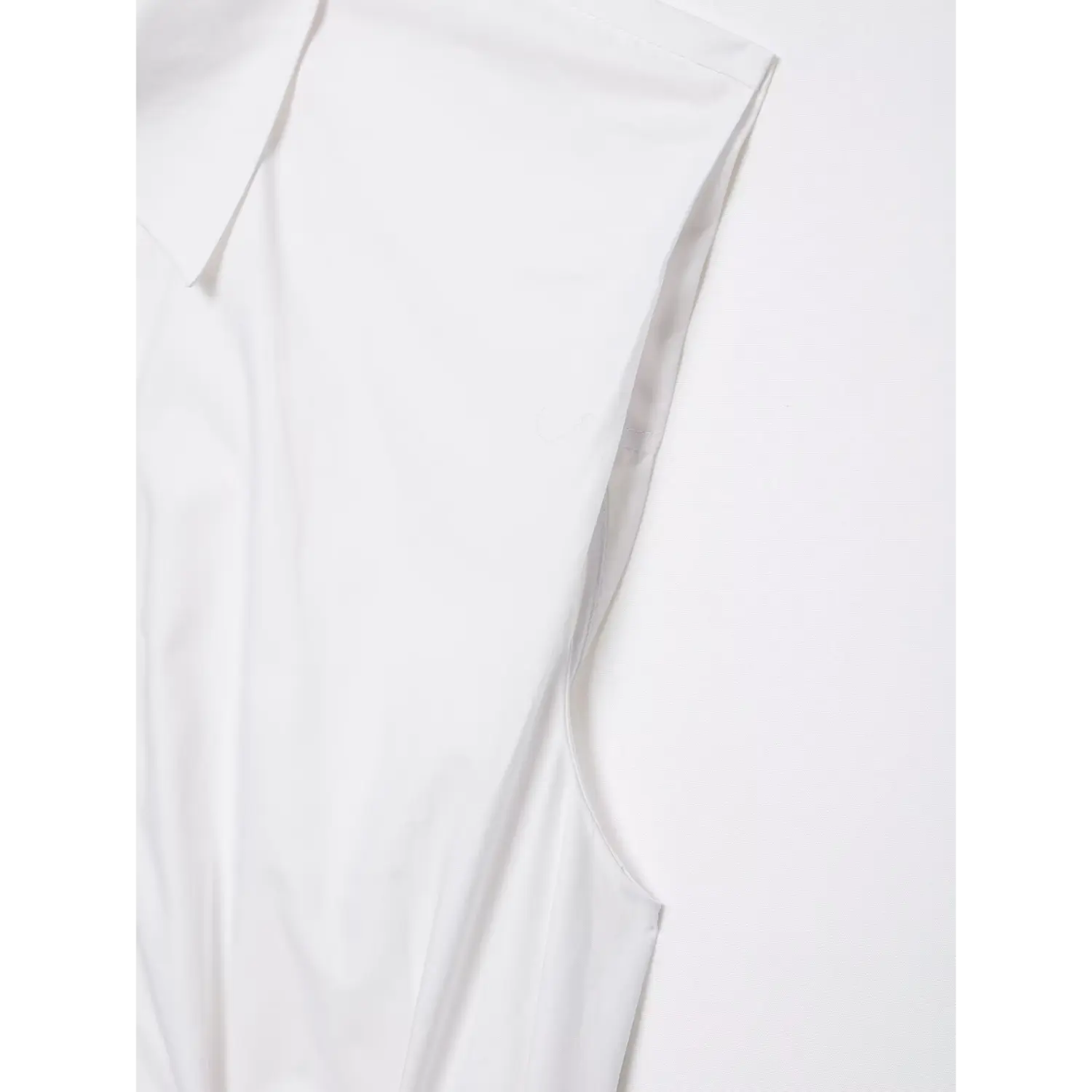 Armhole and side seam detail close-up of white sleeveless peplum top