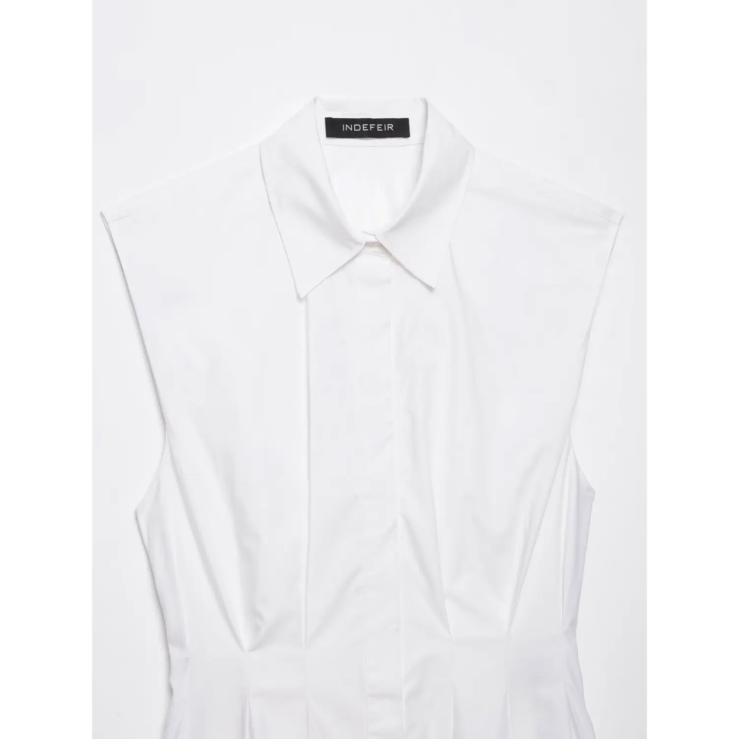 Upper front detail shot of white sleeveless collared peplum blouse