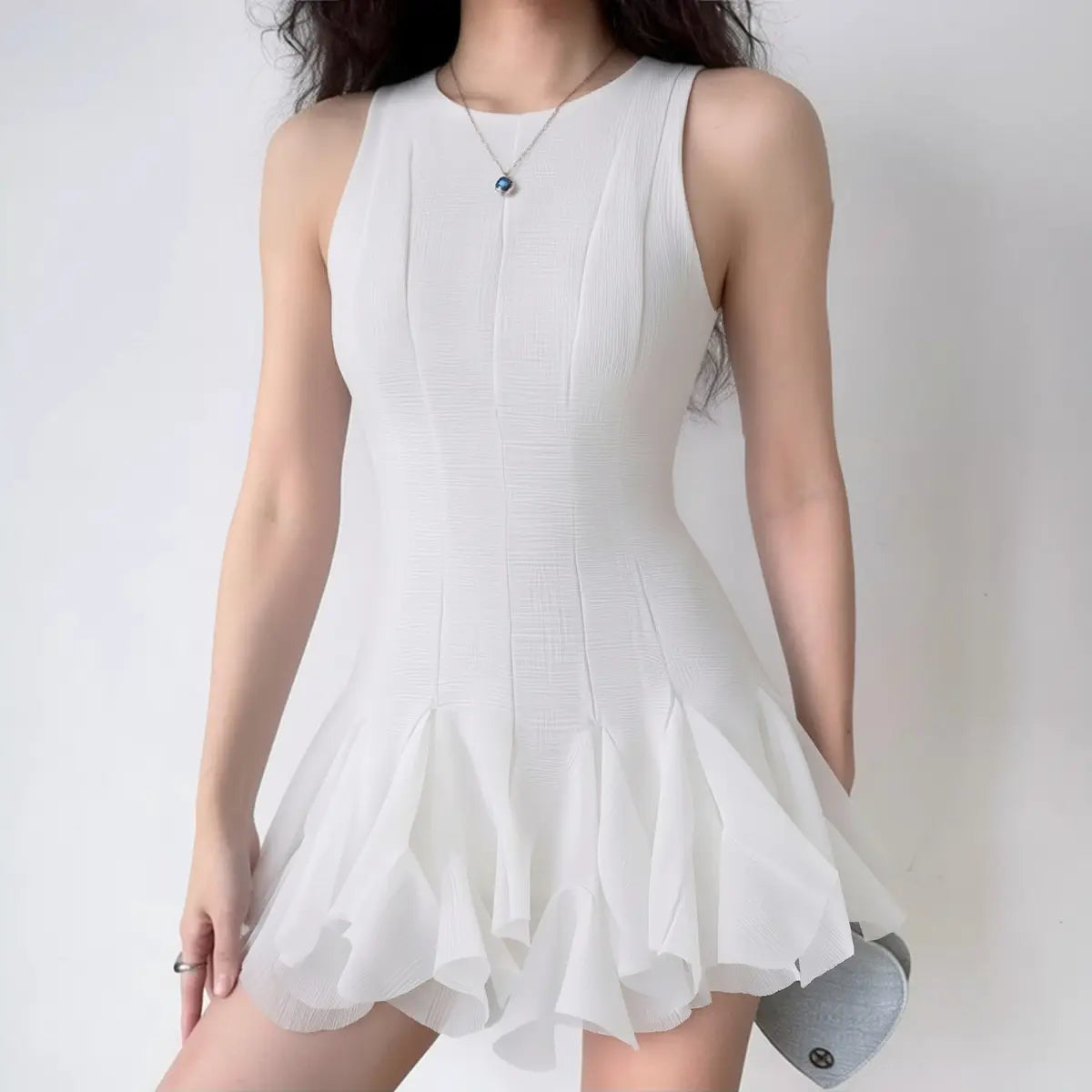 The dress styled on a model, highlighting its fitted silhouette and flowy hem.